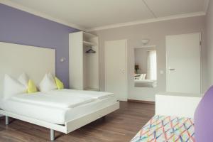 a bedroom with a white bed and a mirror at B&B Toblerina in Ascona