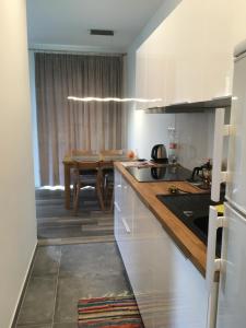 a kitchen with white cabinets and a table with a dining room at Apartmán Smokovec in Vysoke Tatry - Stary Smokovec