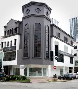 een wit gebouw met een klokkentoren erop bij H Boutique Hotel Xplorer Kota Damansara in Petaling Jaya