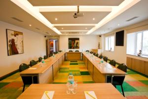 una larga sala de reuniones con mesas y sillas de madera en Lemon Tree Hotel, Ahmedabad, en Ahmedabad