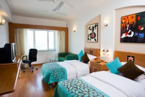 Habitación de hotel con 2 camas y TV en Lemon Tree Hotel, Ahmedabad, en Ahmedabad