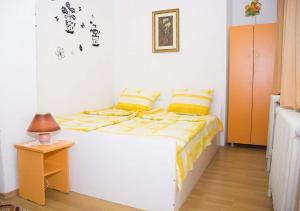 a bedroom with a bed with yellow pillows and a table at Villa Flora in Ohrid