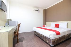 um quarto de hotel com uma cama e uma secretária em RedDoorz near Stadion Manahan Solo em Surakarta