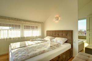 a bedroom with a bed and a large window at Loftas Nidos centre in Nida