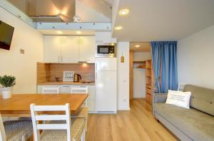 a kitchen and living room with a table and a couch at Loftas Nidos centre in Nida