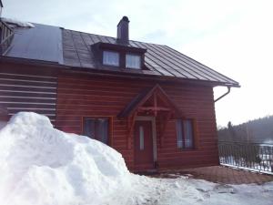 a pile of snow in front of a log cabin at Chata Slunečná louka in Cerny Dul