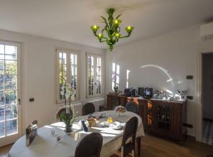 una sala da pranzo con tavolo e lampadario pendente di Villa Contarini B&B a Lido di Venezia