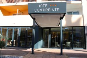 una señal de temperatura del hotel frente a un edificio en Hôtel L'Empreinte en Cagnes-sur-Mer