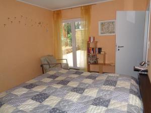 a bedroom with a bed and a chair and a window at Ferienhaus "Pusteblume" in Bad Zwischenahn