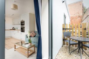 a living room with a blue couch and a table at Stylish Modern City Centre Apartment in Gloucester