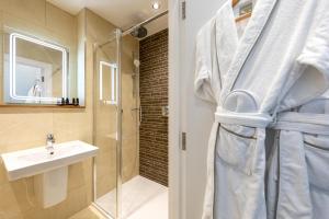 a bathroom with a shower and a sink and a mirror at Sandhills Apartments, Mudeford in Christchurch