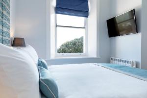 a bedroom with a white bed and a window at Sandhills Apartments, Mudeford in Christchurch