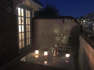 ein Tisch mit Kerzen auf einem Balkon in der Nacht in der Unterkunft Pixie Cottage in Eastbourne
