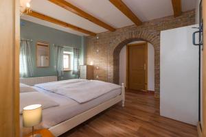 a bedroom with a bed and a brick wall at Chalet GoSlo in Srpenica