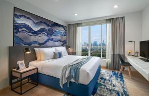 a hotel room with a bed and a large window at Shama Lakeview Asoke Bangkok in Bangkok