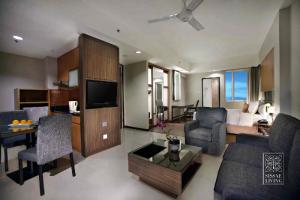 a living room with a couch and a room with a bed at The Malibu Suites Balikpapan by Sissae Living in Balikpapan