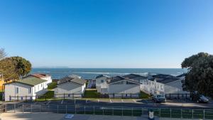 a row of houses with the ocean in the background at Sandhills Apartments, Mudeford in Christchurch
