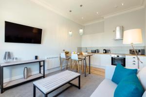 a kitchen and living room with a couch and a table at Sandhills Apartments, Mudeford in Christchurch