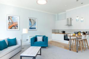 a living room with a couch and a table at Sandhills Apartments, Mudeford in Christchurch