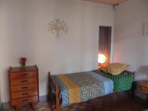 ein Schlafzimmer mit einem Bett und einer Kommode mit einem Nachttisch in der Unterkunft GITE D OMBELINE in Bonnal