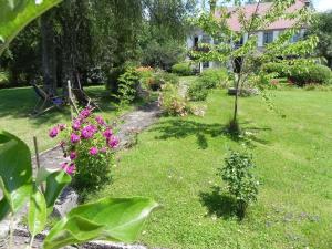 un jardín con flores rosas en un patio en GITE D OMBELINE, en Bonnal
