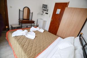 A bed or beds in a room at To Gefyraki Rooms