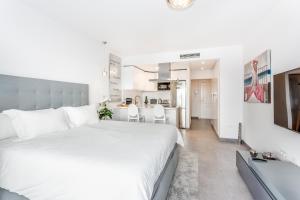 1 dormitorio con 1 cama blanca grande y cocina en by RIVA - Amazing View, Studio in Medina Garden of Puerto Banus en Marbella