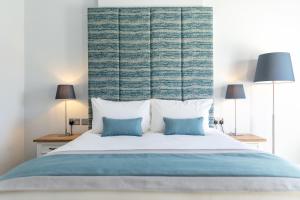a bedroom with a large bed with two lamps at Sandhills Apartments, Mudeford in Christchurch