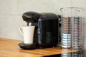 a coffee maker sitting on a counter next to a cup at Sandhills Apartments, Mudeford in Christchurch