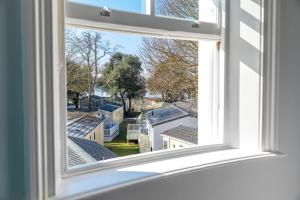 an open window with a view of roofs at Sandhills Apartments, Mudeford in Christchurch