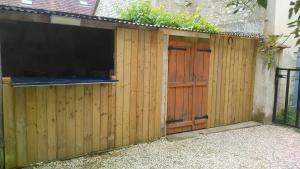 a wooden fence with a wooden door and a gate at Jolie maison de Potier in Accolay