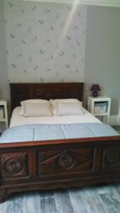 um quarto com uma cama de madeira com uma estrutura de madeira em Jolie maison de Potier em Accolay