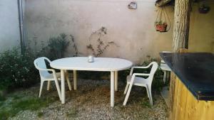 a white table and two chairs in a yard at Jolie maison de Potier in Accolay +12 photos