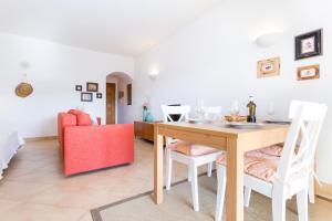 - une salle à manger avec une table et un canapé rouge dans l'établissement Magnoliamar 409, à Lagos