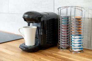 a coffee maker sitting on a counter next to a cup at Sandhills Apartments, Mudeford in Christchurch