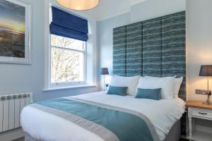 a bedroom with a large bed and a window at Sandhills Apartments, Mudeford in Christchurch +37 photos