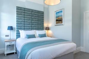 a bedroom with a large bed with a blue wall at Sandhills Apartments, Mudeford in Christchurch