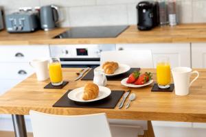 a table with two plates of croissants and orange juice at Sandhills Apartments, Mudeford in Christchurch