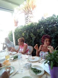 um grupo de pessoas sentadas à mesa a comer em Apartments Boras em Cavtat