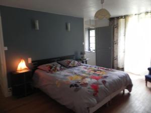 1 dormitorio con cama, lámpara y ventana en L atelier d Ombeline, en Bonnal