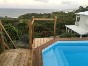 a swimming pool on a deck with a view of the ocean at villa fleurie in Le Moule