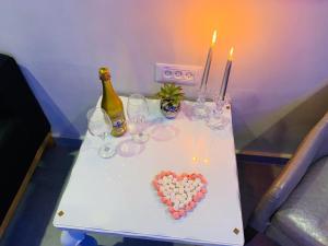a table with wine glasses and a heart on it at Spat Rooms VIP in Petaẖ Tiqwa