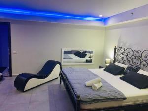 1 dormitorio con 1 cama grande y luz azul en Spat Rooms VIP, en Petaj Tikva