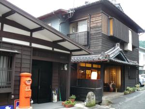 una casa con un edificio de estilo asiático con una puerta en Ryokan Yamashiroya en Yufuin