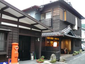 a house with an asian style building with a gate at Ryokan Yamashiroya in Yufu