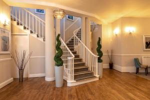 eine Treppe in einem Haus mit weißen Geländern und grünen Pflanzen in der Unterkunft Sandhills Apartments, Mudeford in Christchurch