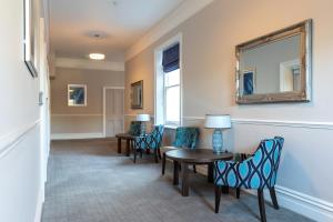 a hallway with chairs and a table and a mirror at Sandhills Apartments, Mudeford in Christchurch