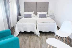 a bedroom with a large white bed and two chairs at Hostal Castillo in San José de la Rinconada +38 photos