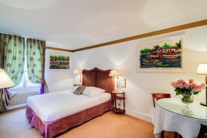 מיטה או מיטות בחדר ב-Villa Escudier Appart-hôtel