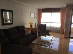 uma sala de estar com um sofá e uma mesa de vidro em Apartamento en Alicante, Plaza de España, zona Mercado, AA em Alicante